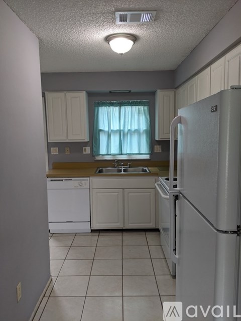 A kitchen with white appliances and cabinets.