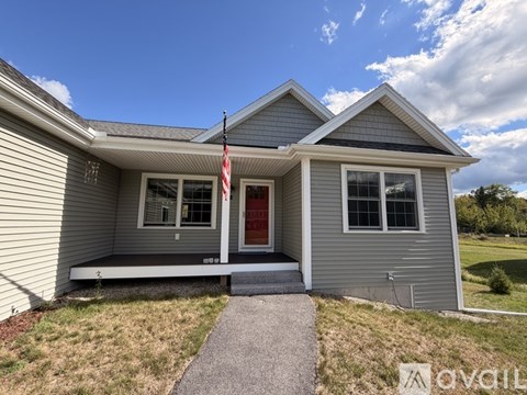A house with a red door and an American flag on the front porch.