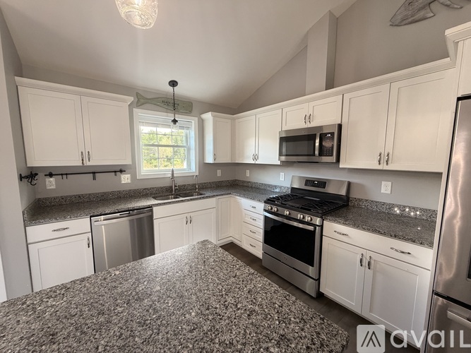 A kitchen with granite countertops and stainless steel appliances.