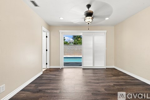 A room with a pool visible through the sliding glass door.