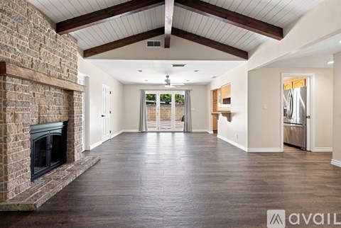 A spacious living room with a fireplace and wooden floors.