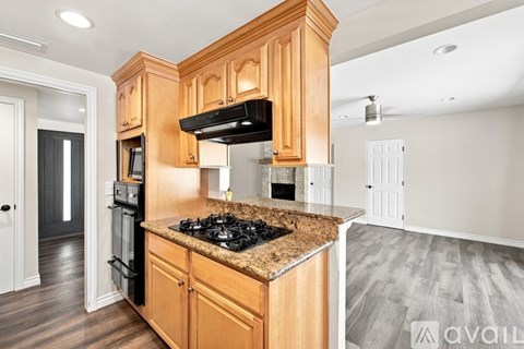 A kitchen with wooden cabinets and a granite countertop.