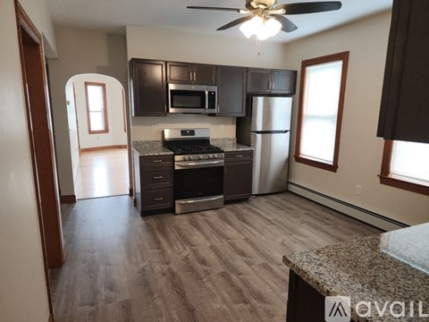 A kitchen with a stove, refrigerator, and microwave.