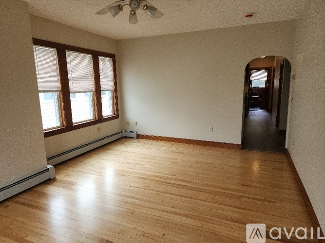 A room with wooden flooring and a ceiling fan.