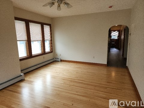 A room with wooden flooring and a ceiling fan.