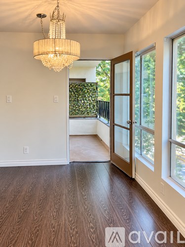A room with a chandelier and wooden floors.