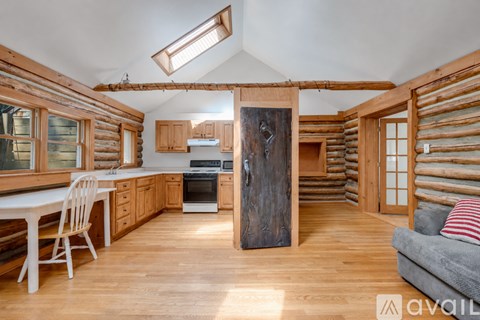A wooden kitchen with a skylight and a dining table.