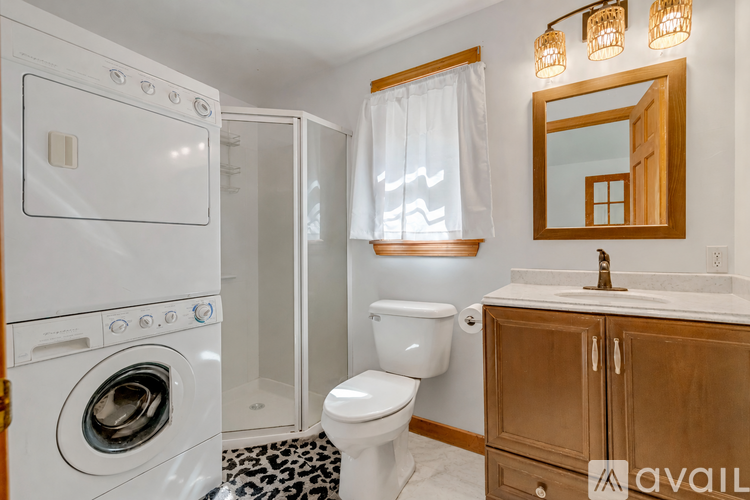 A small bathroom with a toilet, sink, and washer and dryer.