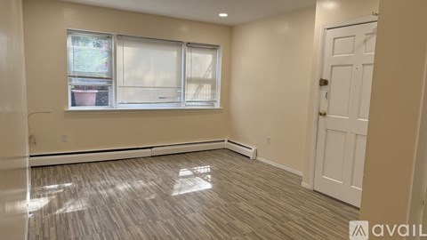 A room with a white door and a window with blinds.