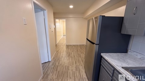 A kitchen area with a black refrigerator and a sink.