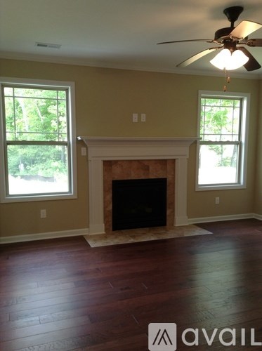 A room with a fireplace and a ceiling fan.