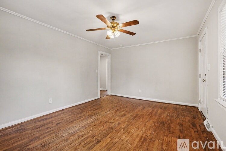 A room with wooden floors and a ceiling fan.