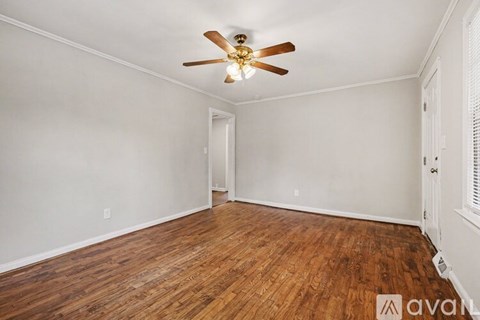 A room with wooden floors and a ceiling fan.