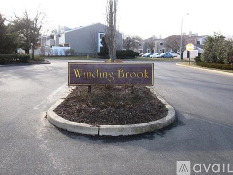 A sign that says "Wincing Brook" is in front of a building.