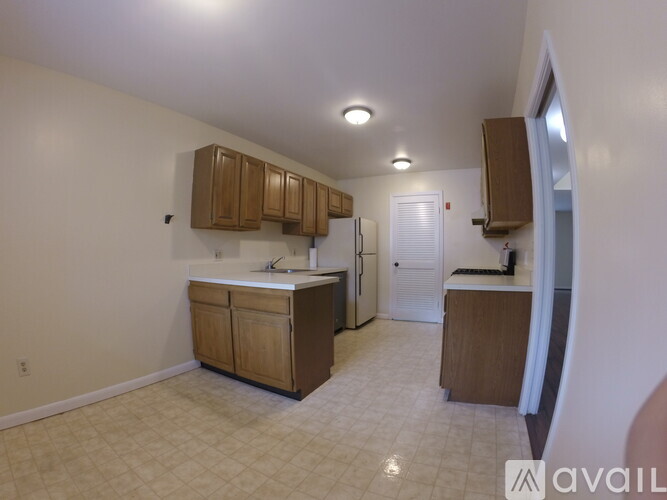 A kitchen with white cabinets and a white fridge.