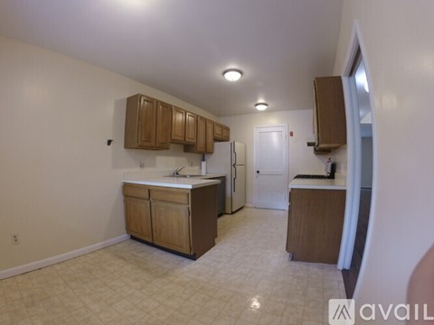 A kitchen with white cabinets and a white fridge.