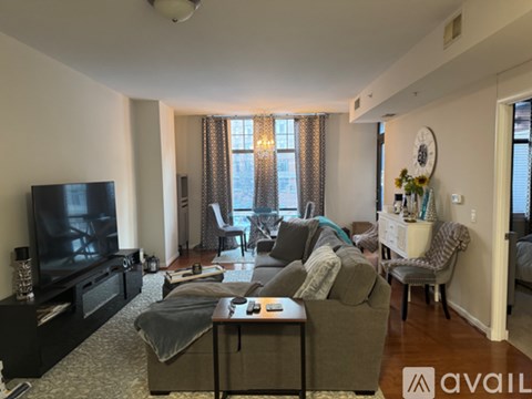 A living room with a grey couch and a black television.