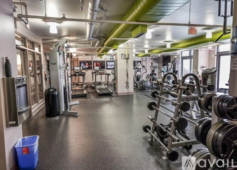 A gym with a variety of equipment including treadmills, weights, and exercise machines.