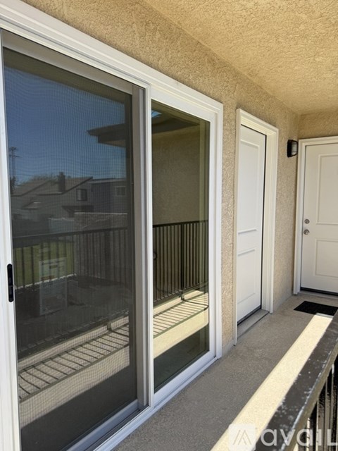 A balcony with a glass door and a white door.