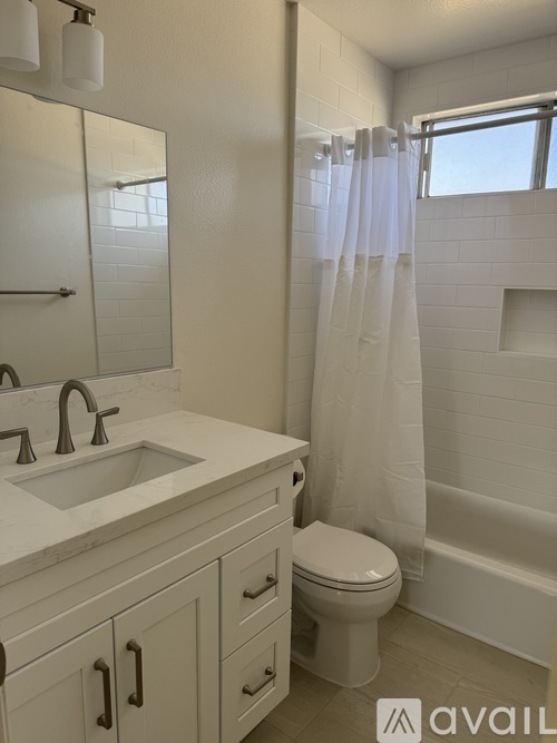 A white bathroom with a sink, toilet and shower.