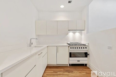 A white kitchen with a stove and cabinets.