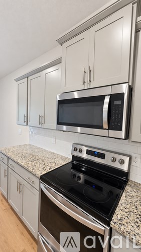 A kitchen with a stove top oven and microwave above it.