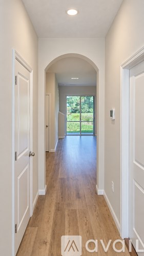 A hallway with a view of the backyard through the window.