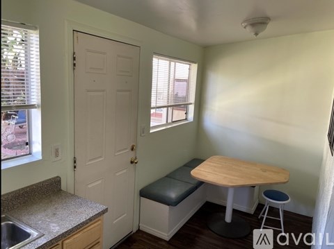 A kitchen with a table and stool in it.
