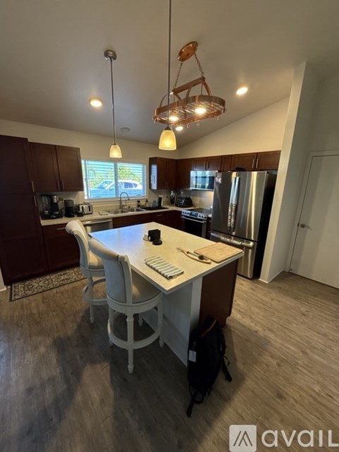 A kitchen with a table and chairs in the foreground and a refrigerator in the background.