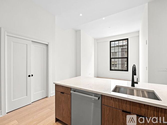 A kitchen with a white counter top and a sink.