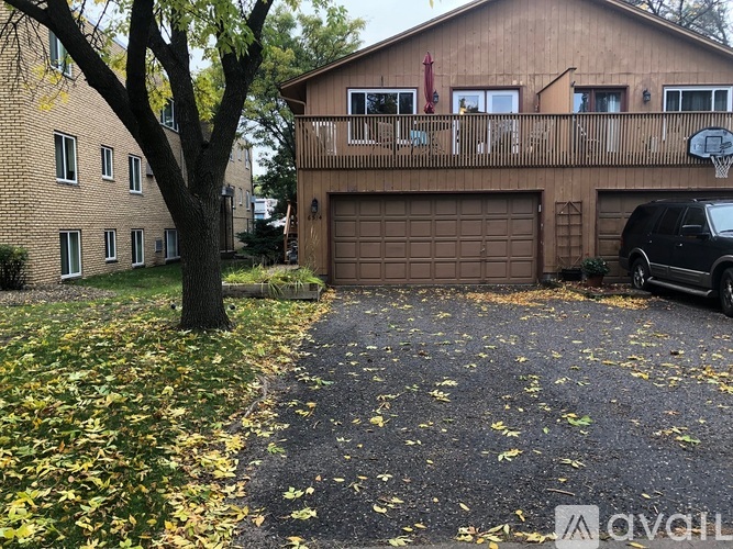 A house with a garage and a tree with yellow leaves.