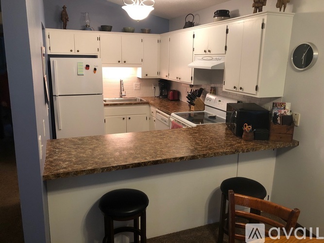 A kitchen with white cabinets and a granite countertop.