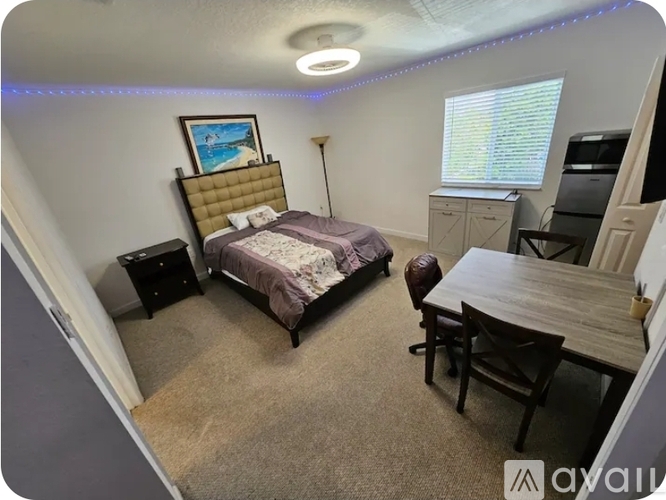 A bedroom with a bed, desk, and chair.
