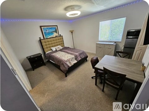 A bedroom with a bed, desk, and chair.