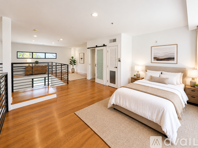 A bedroom with a large bed and a balcony.