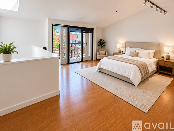 A bedroom with a large bed and a balcony with a view of the outside.