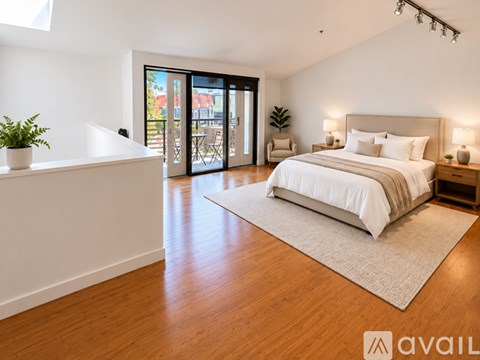 A bedroom with a large bed and a balcony with a view of the outside.