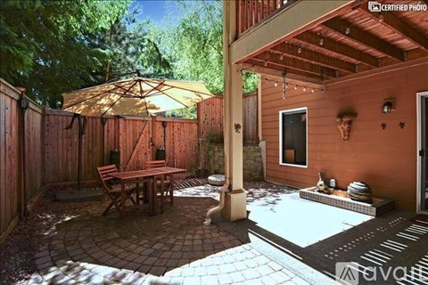 A patio with a table and chairs and a pool.