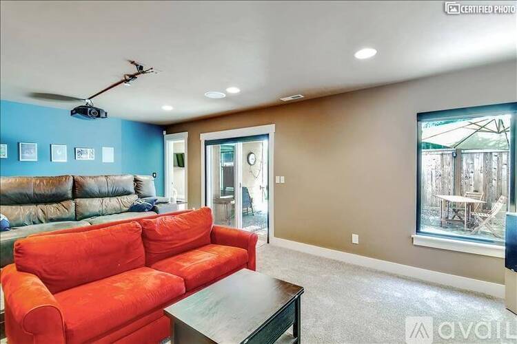 A living room with a red couch and a ceiling fan.