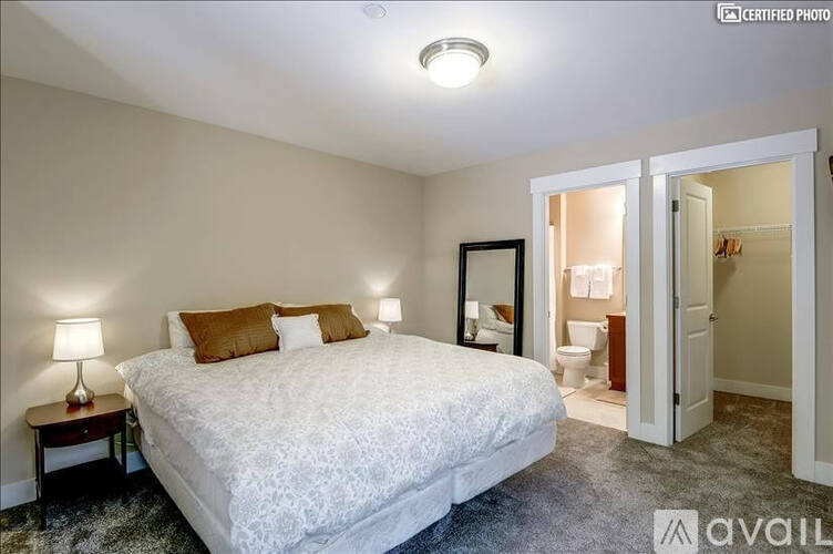 A bedroom with a large bed and a mirror on the wall.