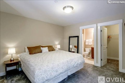 A bedroom with a large bed and a mirror on the wall.