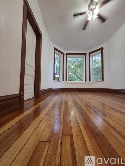 A room with wooden floors and a ceiling fan.