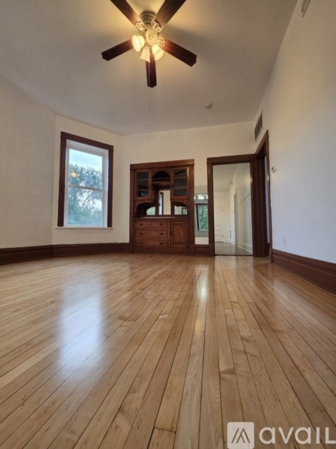 A room with wooden flooring and a ceiling fan.