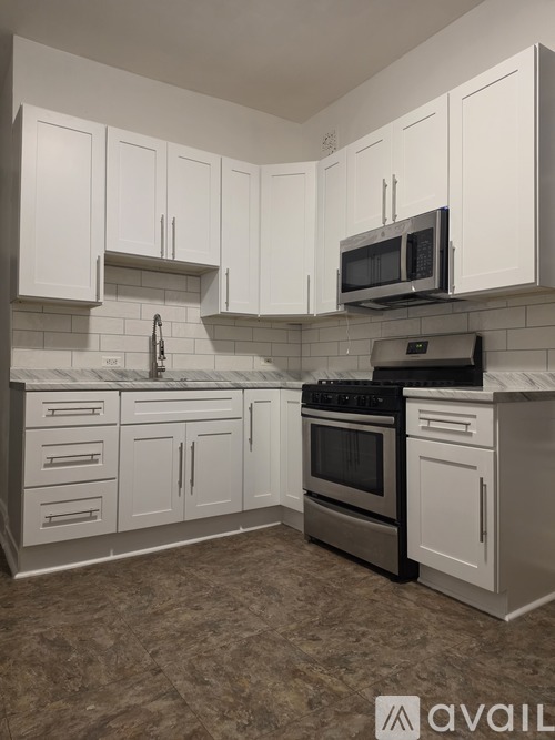 A kitchen with white cabinets and a black stove top oven.