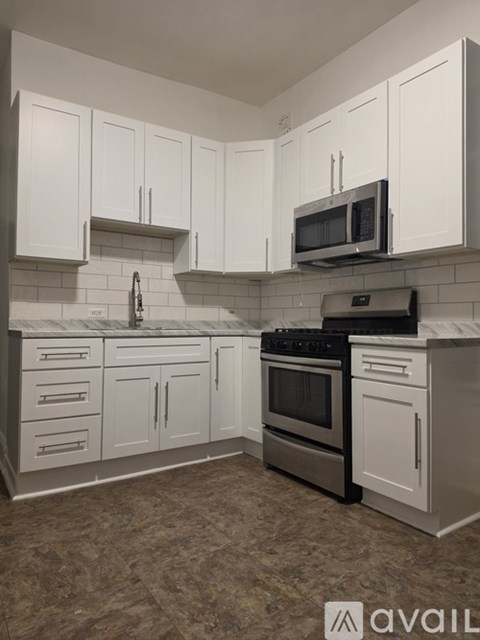 A kitchen with white cabinets and a black stove top oven.