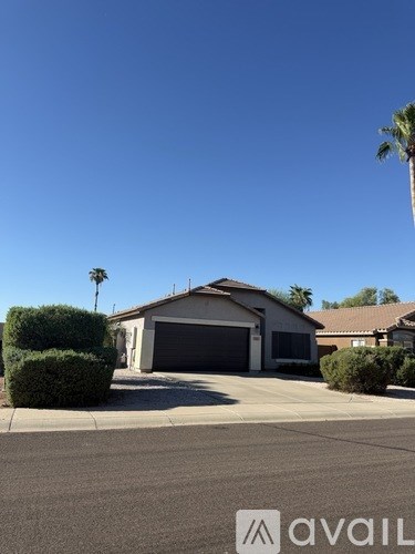 A house with a garage and a driveway in front of it.