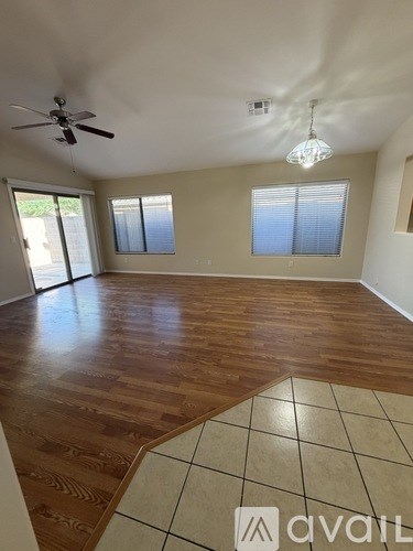 A room with wooden flooring and a ceiling fan.