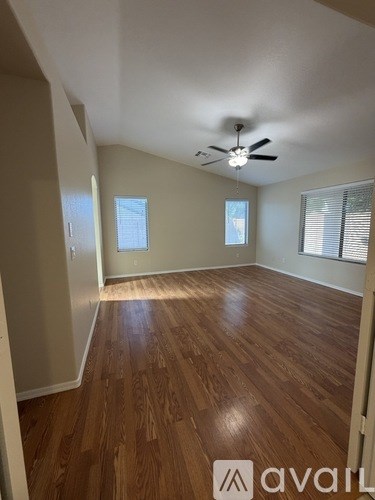 A room with wooden flooring and a ceiling fan.