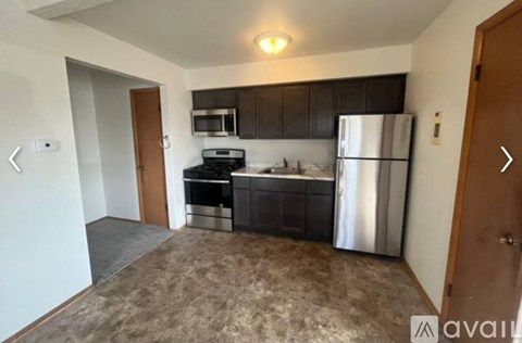 A kitchen with a refrigerator, microwave, and stove.