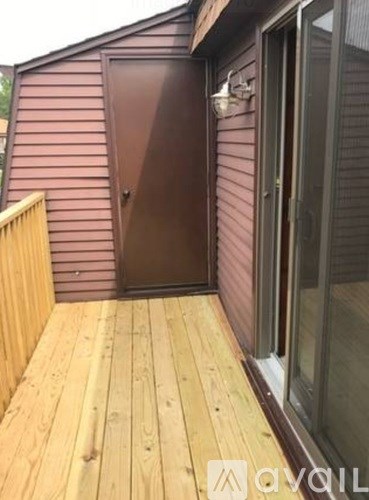 A wooden deck with a brown door and a glass window.